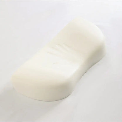 White curved memory foam pillow with handprint indentation on a white background