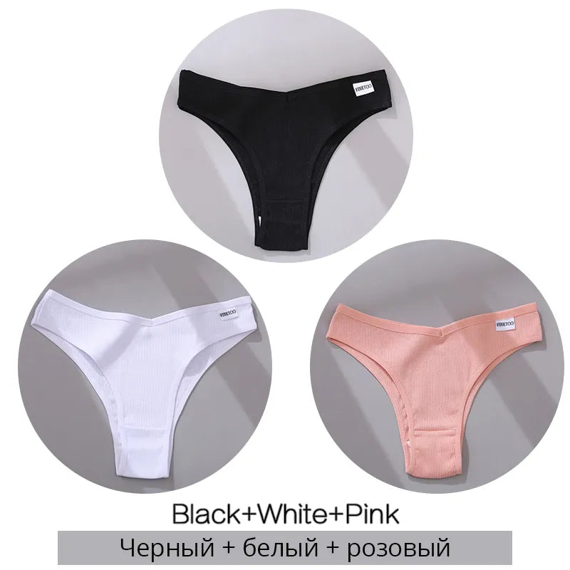 Set of black, white, and pink ribbed cotton thong underwear with label on grey background