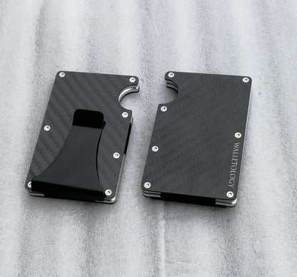 Two black carbon fiber wallets with metal screws and a clip, one showing Walletology logo, on a gray fabric surface