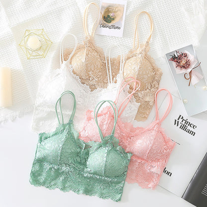 Pastel lace bralettes in green, pink, beige, and white on white textured fabric with candles and magazines